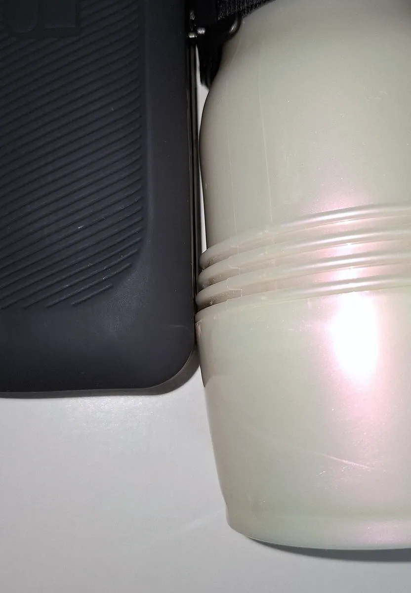 Close-up of the base of a Fleshlight case pressing against the body of the Handy 2