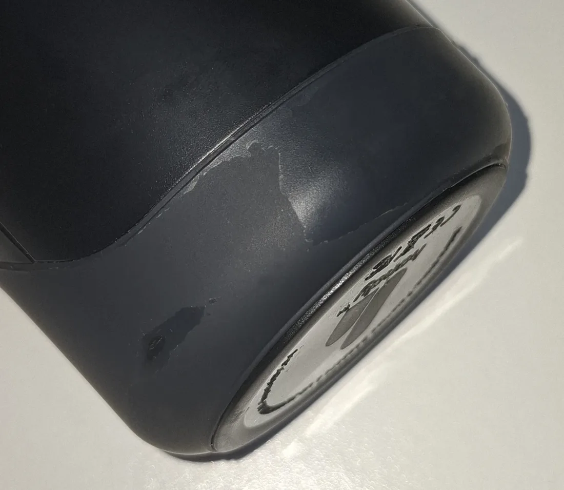 The lower edge of a Handy where the soft touch coating has worn to a shinier surface along the ridge